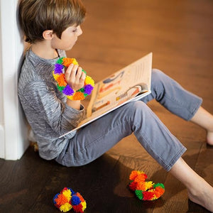 Boy Fidgeting with Tangle while reading Tangle Brain Tools Hardcover Book